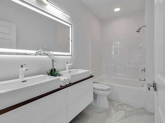 Full bathroom: new vanities, mirror, light fixtures and shower head. Double vanity and shower/tub combo.