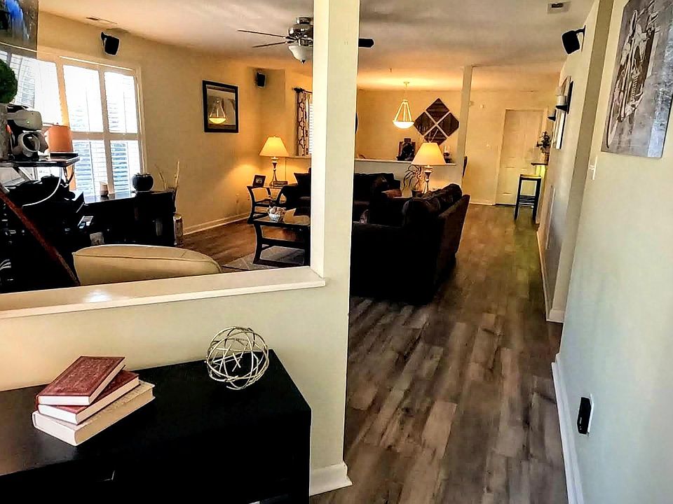 View from the front door opening into the open-concept floor plan and main living area. Note the security system panel for optional added peace of mind, with a second panel in the main bedroom.