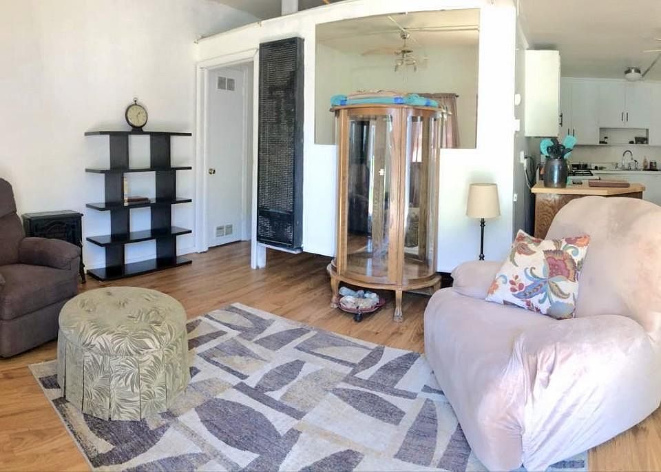Panorama view of living room leading to dining room area that blends into the kitchen.