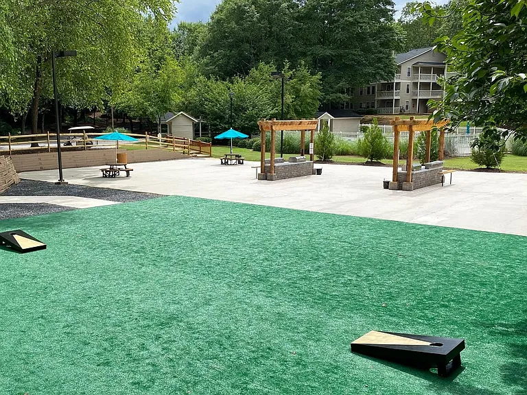 Social area with corn hole boards and grilling area