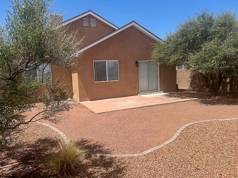 Spacious landscaped backyard and patio with mature trees and xeriscape