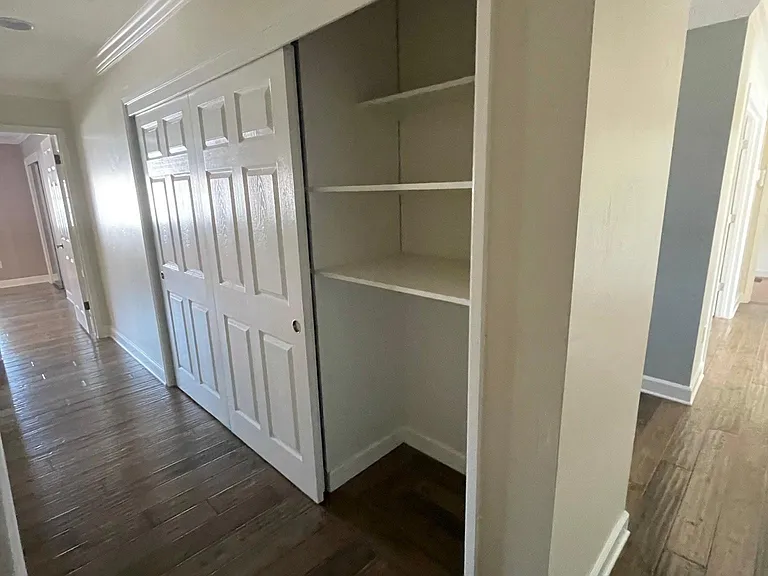 Hallway with 3 large linen closets and sliding doors. Plenty of storage!