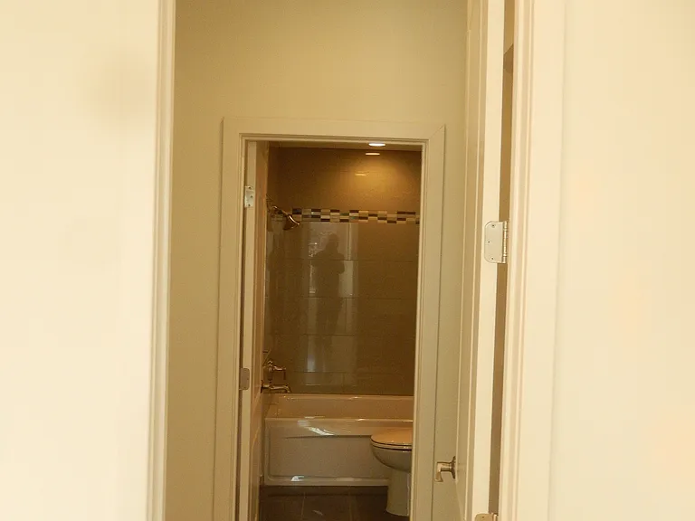 Open double closet leading to the en suite bathroom from the master bedroom.