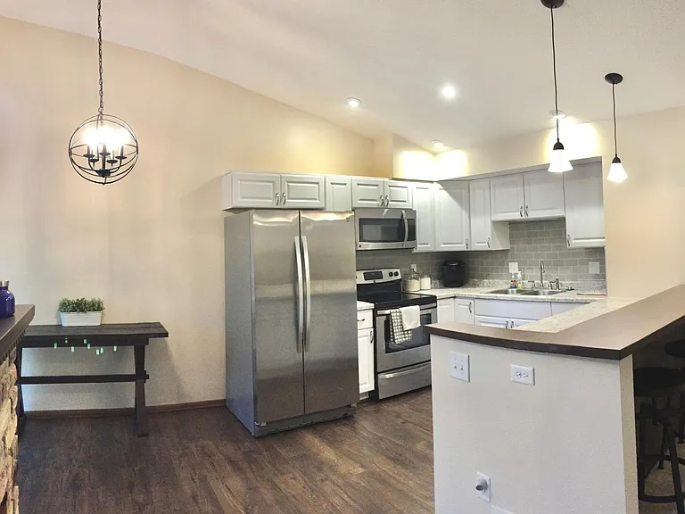 Fully remodeled kitchen with new stainless steel appliances, updated lighting and a custom bar height countertop.