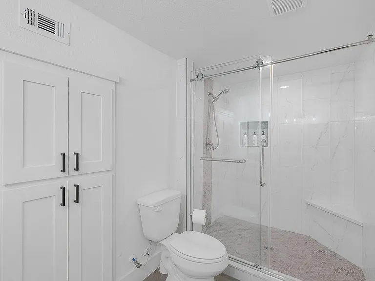 Enlarged shower space with sitting area for the primary bathroom
