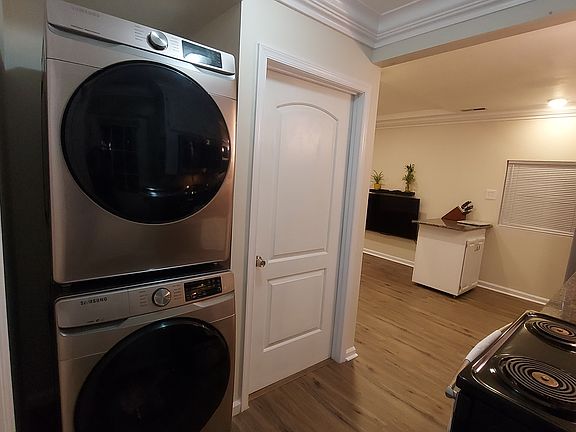 Photo taken from side door showing washer & dryer, door to bedroom 2 into the living room