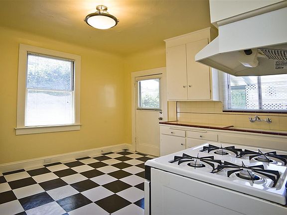 Kitchen looking at back door. Designated parking spot steps away.