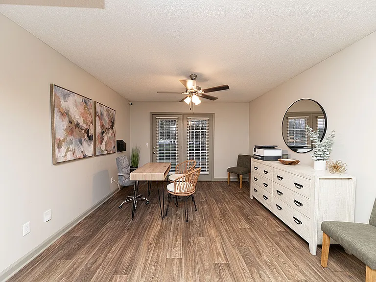 Spacious living room with hardwood-style flooring & ceiling fan