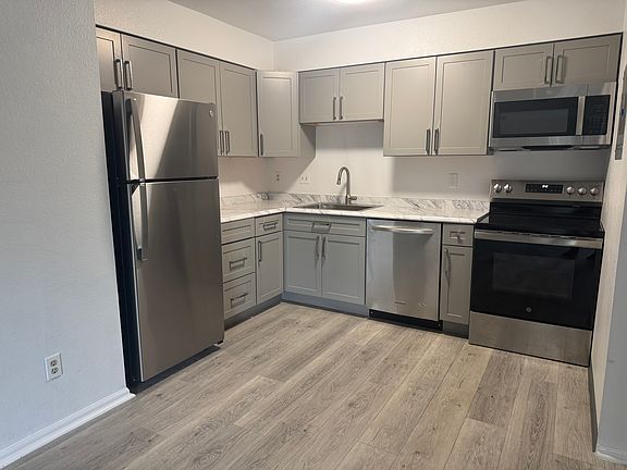 Beautiful kitchen with new light grey cabinets and hardware as well as lovely appliances including brand new refrigerator and microwave as well as all new fixtures