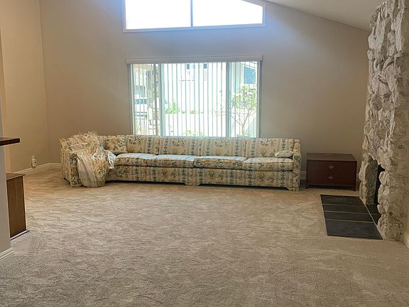 Living room with stone fireplace, large windows