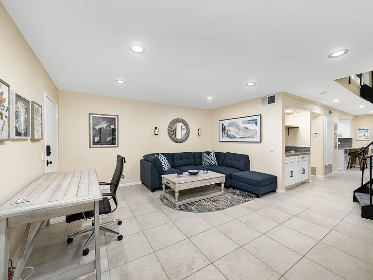 Living room area with desk and smart TV.
