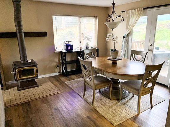 Dining room next to living area and kitchen (upstairs). Entrance to full fenced back yard with small deck. Back yard is made up of terraced grass levels and rockery.
