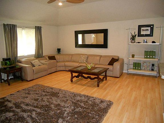 The living area is huge with wood laminate flooring and high ceilings.