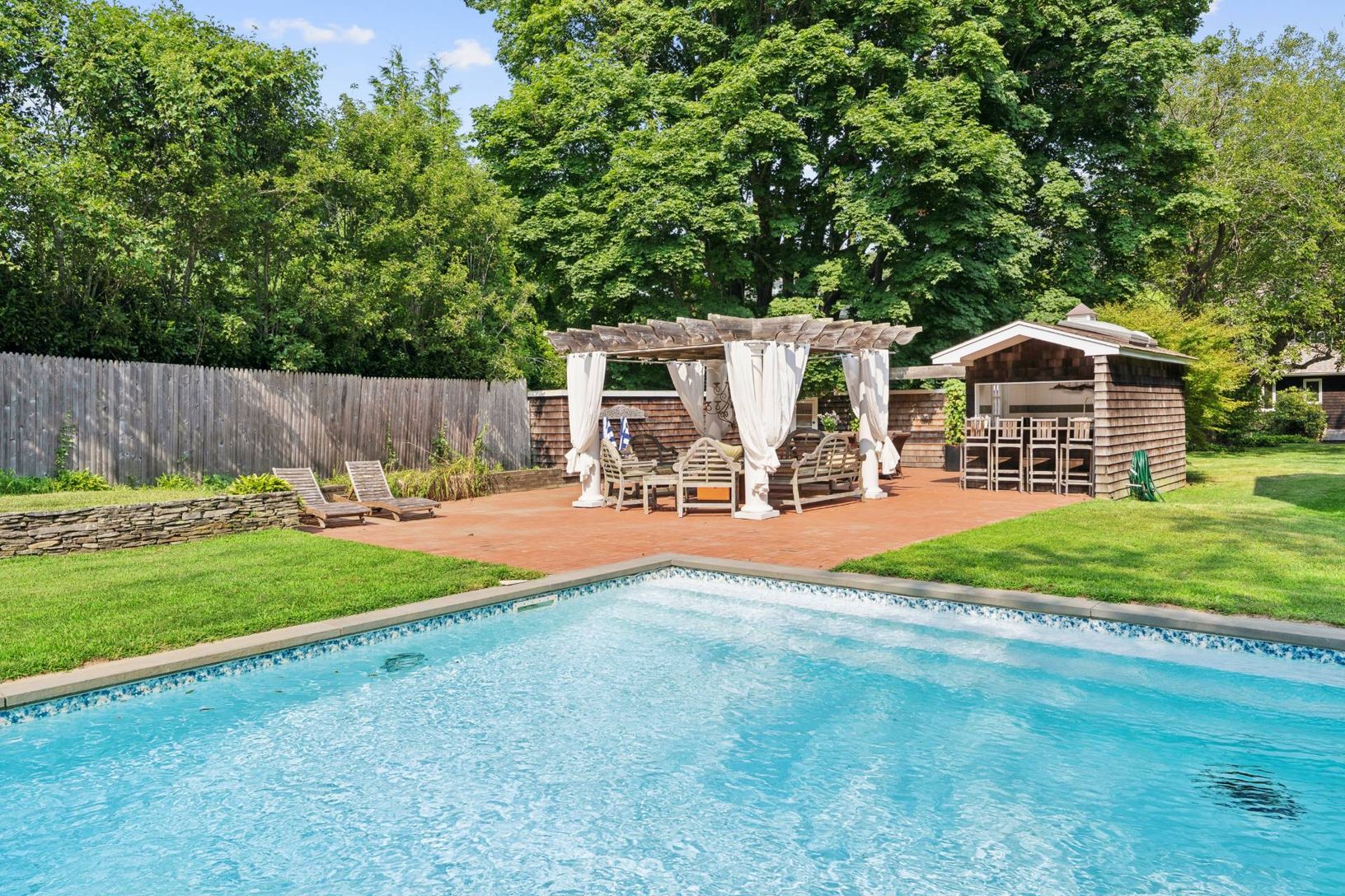 view from pool to pergola and outdoor kitchen