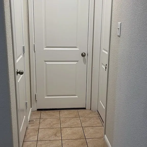Guest room door to the right, with window view to the front of the house, Garage dooor in the middle, closet door to the left