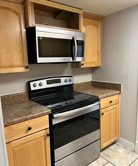 Kitchen w/stove and microwave above.