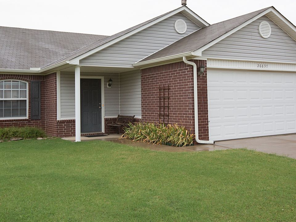 Dark brick home with manicured lawn