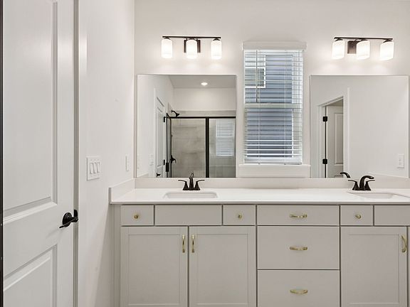 The primary bathroom offers dual vanity sinks and a walk-in shower.
