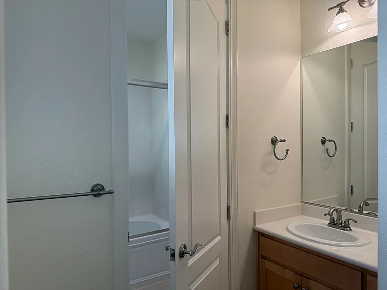 Spacious Bedroom #2 features multiple windows, vinyl flooring, walk-in closet, a separate bathroom sink and share a Jack-and-Jill style bathroom for the bathtub and toilet.