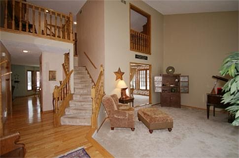 One step down to the formal living room with 2-story ceiling