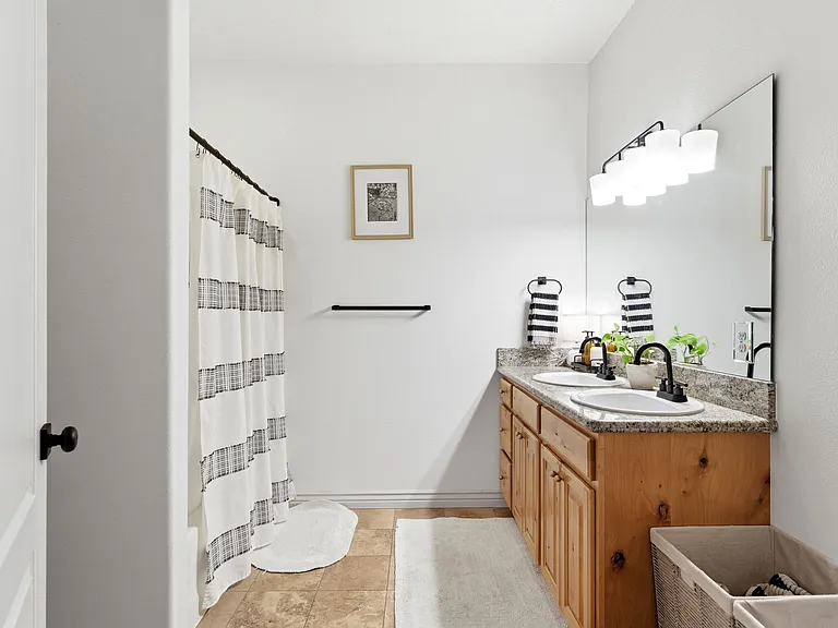 Ensuite bathroom with dual sinks, shower, and tub