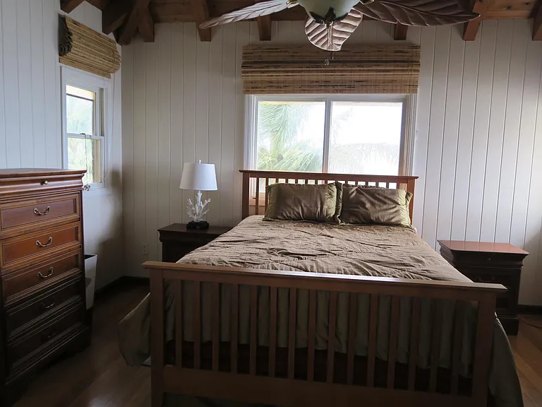 Second upstairs bedroom with a queen size bed and dressers.