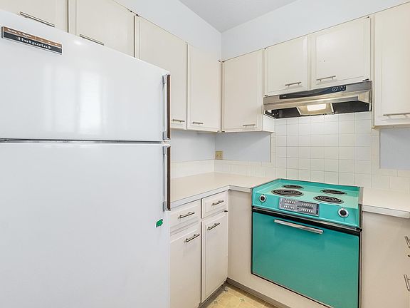 kitchen with 1 year old refrigerator vintage range/oven, updated counter tops, painted cabinets with new pulls