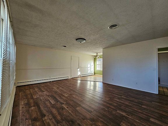 Note baseboard radiant hot water heat that runs along walls and provides quiet constant heat without blowing dust.