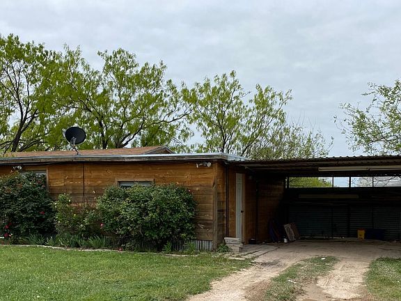 Front of apartment and view of covered parking.