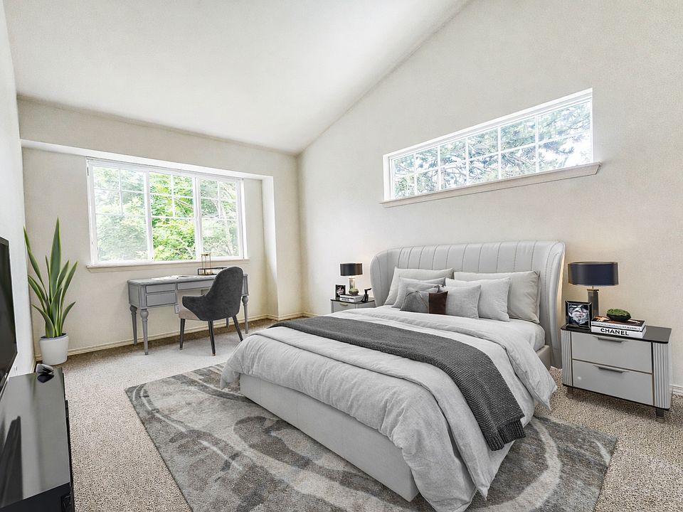 Spacious primary bedroom with vaulted ceilings and abundant natural light