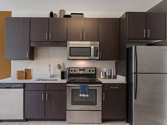 Open concept kitchen with granite countertops, stainless steel appliances, tile backsplash and hard surface flooring