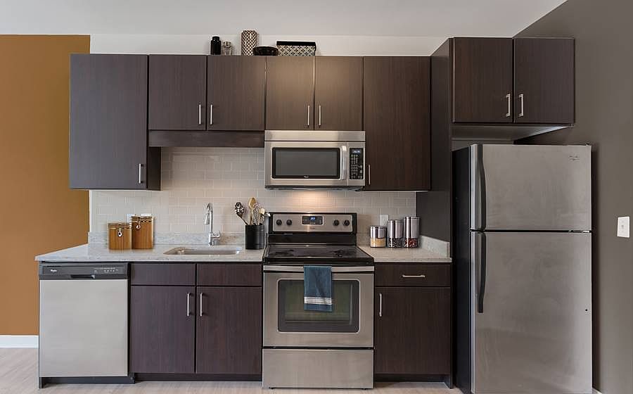 Open concept kitchen with granite countertops, stainless steel appliances, tile backsplash and hard surface flooring