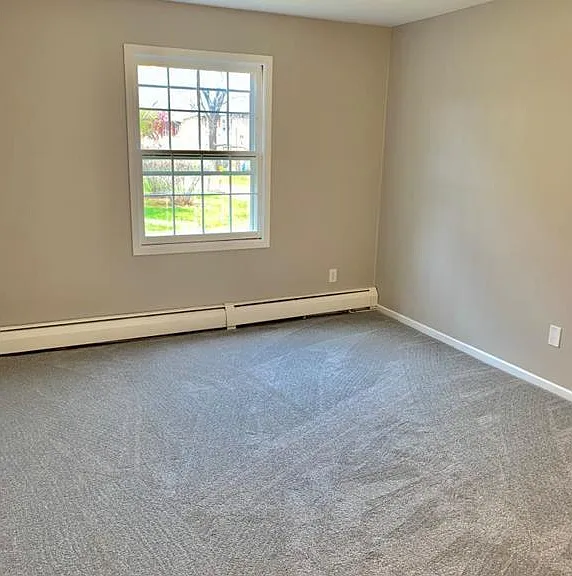 Master bedroom, with a view to the green lawns outside.