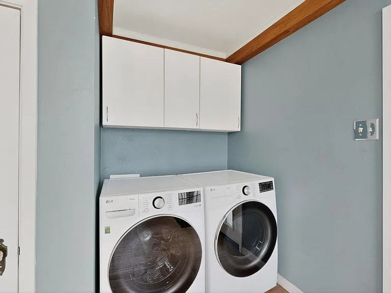 A functional laundry area with a washer and dryer, complemented by the built-in storage cabinets above