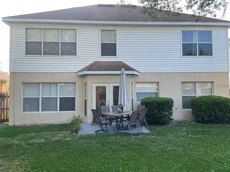 BACK OF THE HOME WITH AN OPEN AIR PATIO