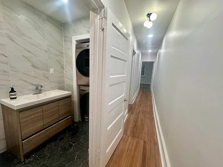 LED-lit hallway from living room/kitchen to bathroom, laundry, and bedrooms.