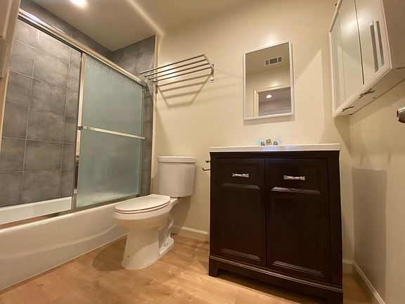 SPACIOUS BATHROOM WITH FULL BATH TUB, ELONGATED TOILET AND MULTIPLE MEDICINE CABINETS