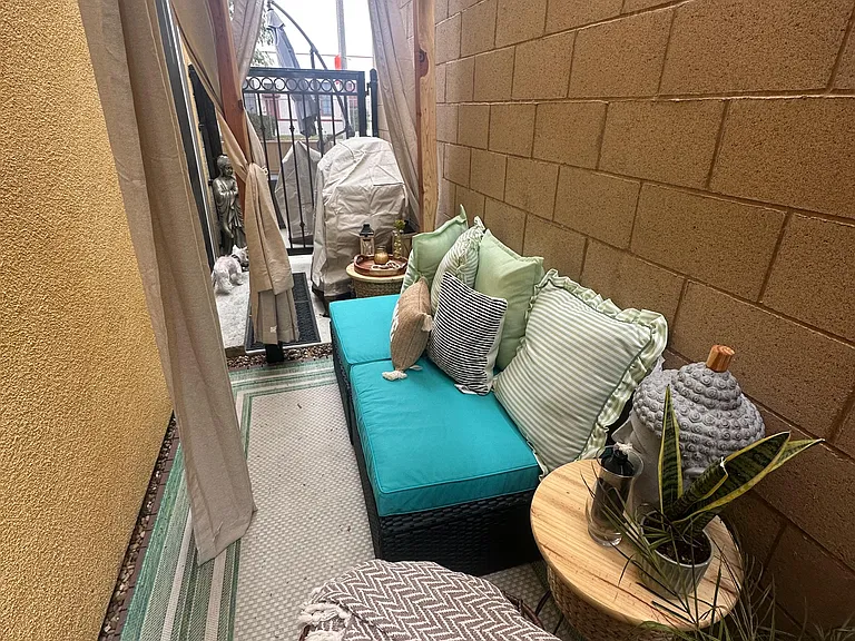 Private, covered patio lounge with outdoor seating, side tables, and shade for relaxing or entertaining.