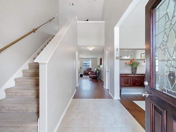 The two story entrance is a nice surprise for the understated front elevation! Light and bright formal dining just to the right of the entry and updated flooring leads into the open concept living area.