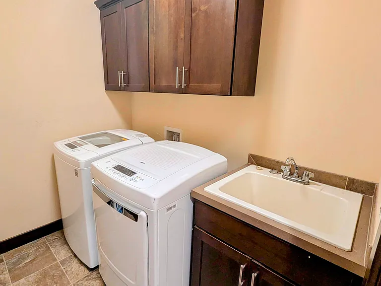 Utility Room with washer, dryer, large utility basin and closets