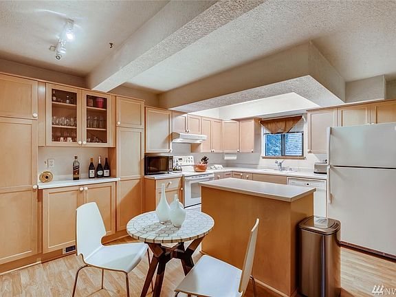 Tons of wood cabinets in this kitchen, complete with extra built-ins and an island for great prep space!  Glass display cupboard too!