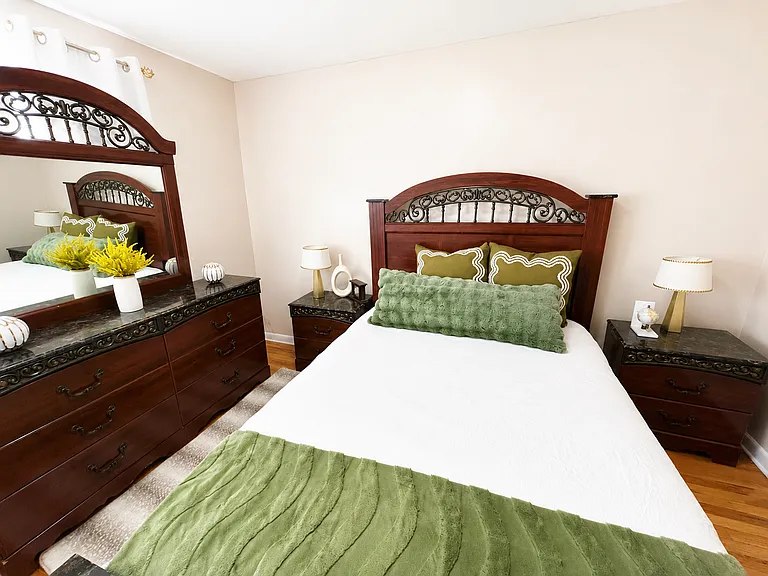 Spacious, fully furnished private bedroom with hardwood floors, coordinated furniture and ample dresser storage.