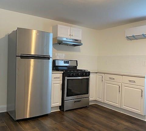 Spacious updated kitchen with stainless steel appliances, including dishwasher, stove, and refrigerator. Ample cabinet space!