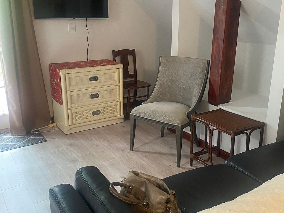 The living room area has a leather sofa, guest chair, and new 40" smart TV.