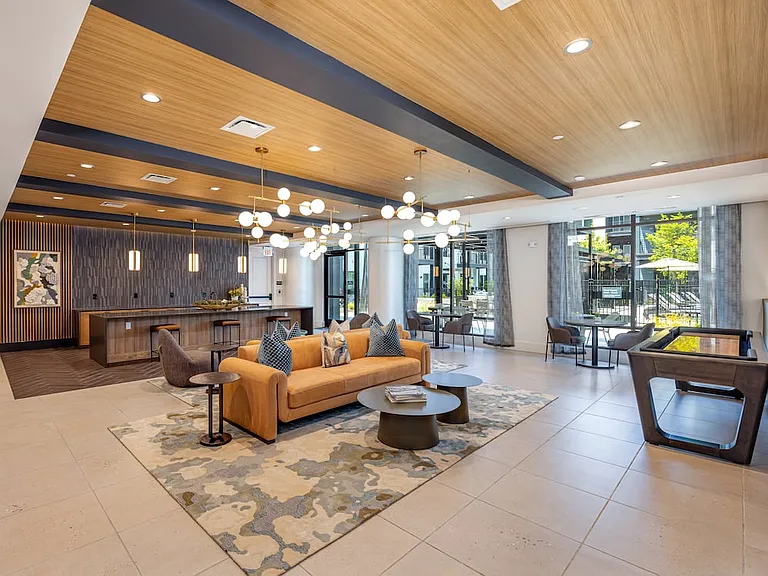 Lounge with entertaining kitchenette, multiple seating areas, and game table