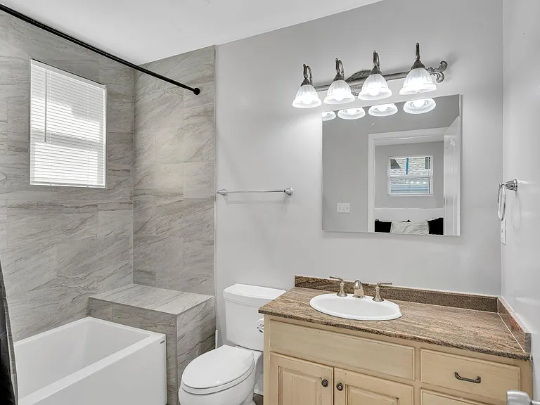 Modern full bathroom featuring a sleek vanity, clean toilet, and stylish tub/toilet combo for your comfort and convenience!