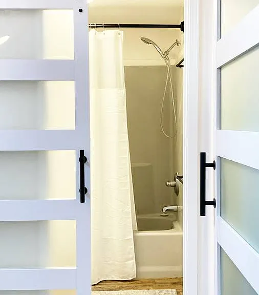 Behind the sliding barn-doors is a generous bathroom with a soaking tub. Bubbles await...