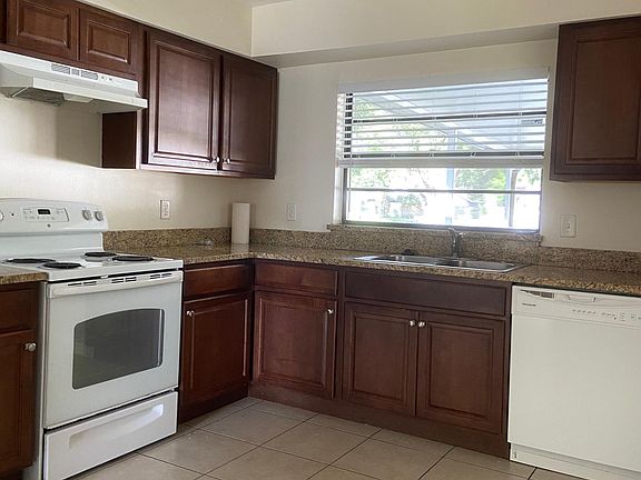 Bright kitchen overlooking patio with updated cabinets and granite countertops.