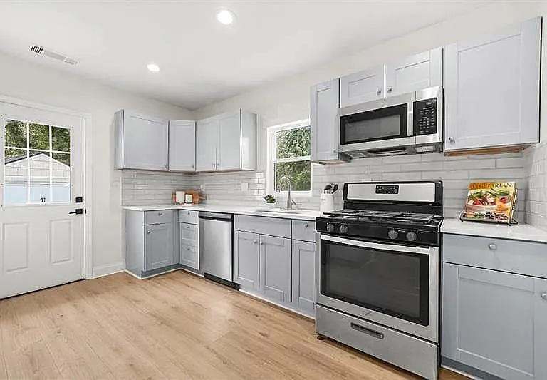 Updated kitchen with ample cabinet storage, subway tile backsplash, and full stainless appliance suite for everyday cooking.