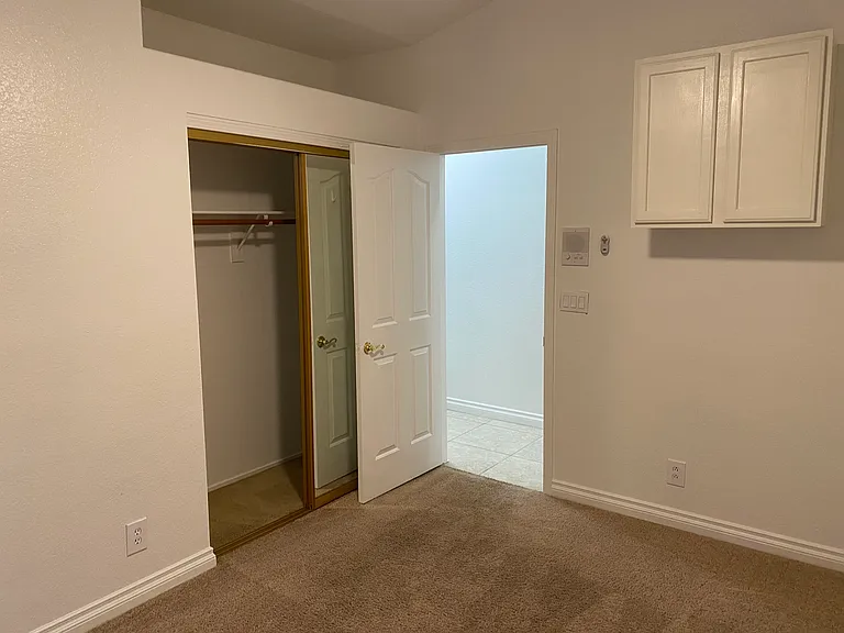 Bedroom #2 - Built-in cabinets, mirrored closet doors, ceiling fan, pot shelf for plants, stuffed animals, books, decor.